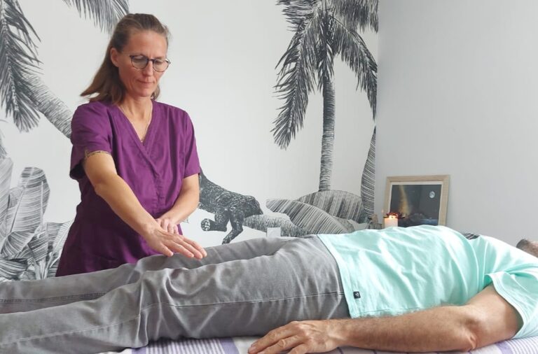 Séance de magnétisme réalisée par une praticienne sur un homme allongé sur une table de soin